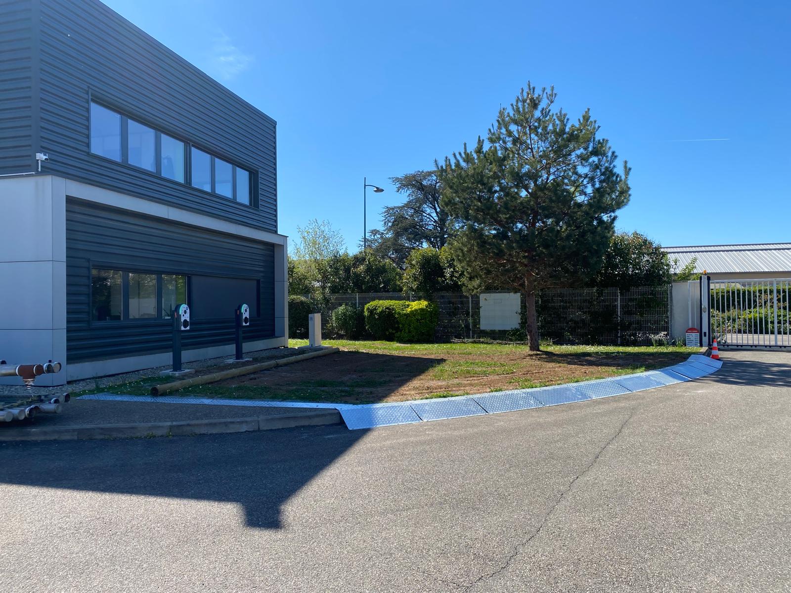 Aire de recharge de véhicules électriques de 75 m² sur caillebotis métallique préservant l'espace vert